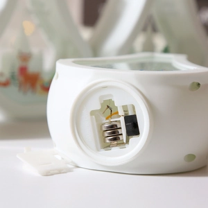 Detail view of the white decorative lamp base showing the battery compartment and switch