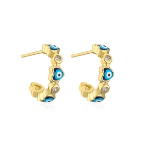 Macro detail of 18K gold plated C-shaped hoop earrings with zircon evil eye heart design