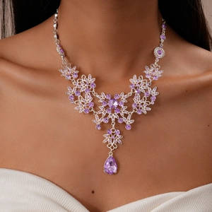 Macro detail of silver floral necklace with purple water drop crystal and rhinestones