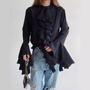Elegant black ruffle chiffon blouse with long sleeves paired with light blue distressed jeans