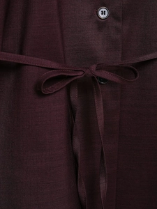 Detailed view of dark purple satin blouse featuring buttoned placket and waist tie belt