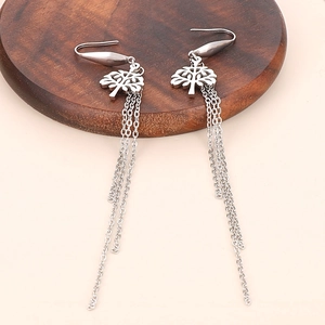 Detail shot of silver tree of life earrings with long chain tassels on wooden tray