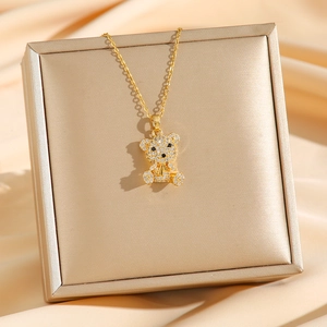 Magnifique collier d'ours doré avec cristaux scintillants sur un fond de soie champagne luxueux