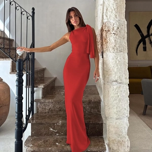 Elegant one-shoulder red evening gown with a flowing tie-strap on marble stairs