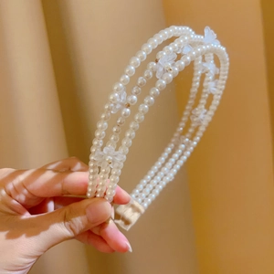 Detailed macro view of a three-layer pearl headband with frosted flower ornaments