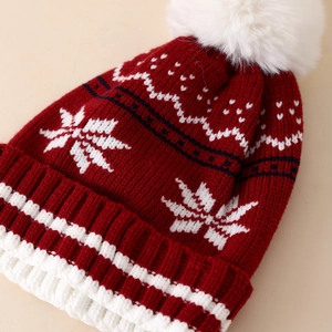 Winter knit hat with red and white snowflake pattern and fluffy pompom for kids