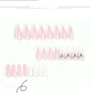 Detailansicht von rosa Ombre-Press-on-Nägeln mit Glitzer und Strass auf weißem Hintergrund