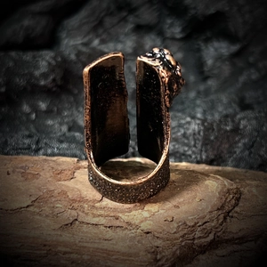 Macro detail of vintage bronze ring showing rustic textured finish and relief pattern