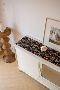 Close-up of floral jacquard table runner with pink flowers on black fabric base