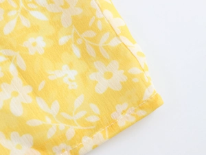 Detailed close-up showing stitching on yellow floral French tea break dress fabric