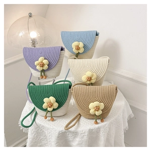 Detalle de bolsos de algodón trenzado de colores con dijes de flores y correas tejidas