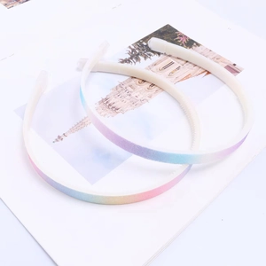 Set of two gradient rainbow thin headbands for girls on a white book minimalist display