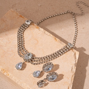 Détail de la parure de collier multicouche et boucles d'oreilles en strass argenté
