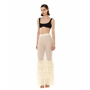 Detail of beige lace skirt featuring layered ruffled hem and sheer floral pattern textile