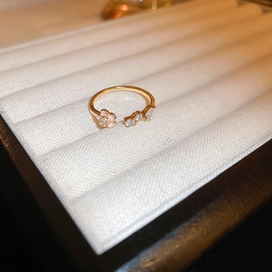Macro detail of gold plated open ring featuring pink enamel flower and sparkling zircons