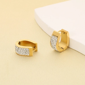 Detailed macro shot of gold-plated stainless steel U-shaped earrings with pave rhinestones