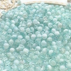 Macro detail of 10mm light blue cracked glass beads for DIY jewelry making