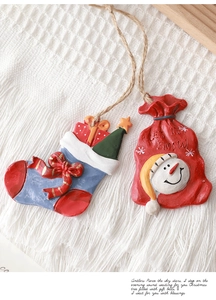 Detail of resin Christmas tree ornaments featuring blue stocking and red snowman gift bag