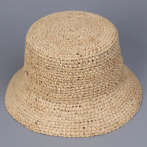 Macro view of hand-woven raffia texture on top of a summer flat straw bucket sun hat
