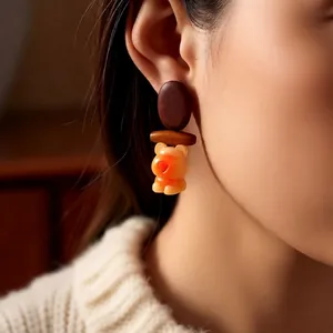 Cartoon wooden bear pendant earrings with silver needle on model for casual retro style
