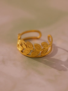 Detail of 18k gold plated stainless steel ring with leaf pattern and grain texture