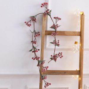 Mini ghirlanda natalizia con bacche rosse ed effetto neve su scala in legno