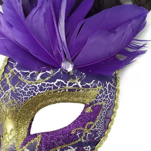Dettaglio della maschera di piume viola con finitura screpolata bianca e bordi d'oro