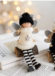 Detailed close-up of a Christmas plush angel doll in white knit dress on a wooden stand