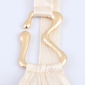 Dettaglio vestito elegante in raso con fibbia dorata e nastro beige plissettato