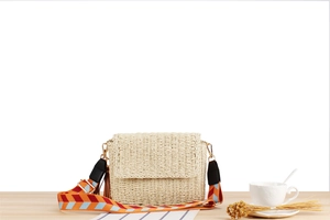 Detail of hand-woven crossbody bag with a colorful geometric patterned strap