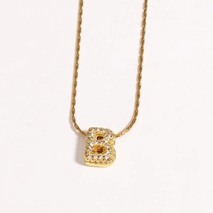 Détail d'un collier doré avec pendentif lettre B style ballon 3D serti de zircons brillants