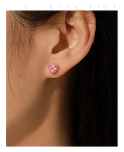 Close-up of pink heart-shaped S925 sterling silver stud earring with sparkling zircon stone