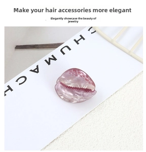 Detail of pink shell-shaped hair clip with translucent resin texture and realistic ridges