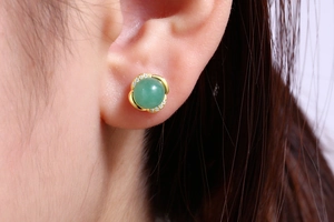 Close-up of S925 silver green aventurine stud earring with gold flower setting on ear