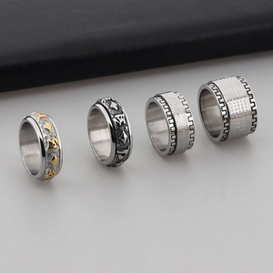 Close-up of stainless steel spinner ring with engraved Buddhist mantra and matte finish