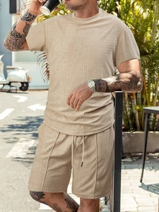 Detail of men's beige summer set featuring geometric textured knit fabric on shorts and tee