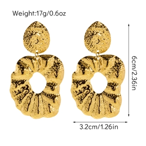 Détail des boucles d'oreilles en titane plaqué or, longueur 6cm et texture martelée