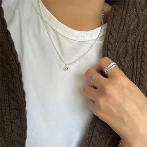 Detail of 925 sterling silver bead necklace and minimalist ring set on a model