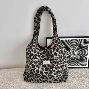 Detail of leopard print faux shearling tote bag showing texture and white woven label