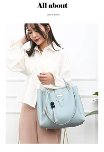 Detail of light blue leather handbag with gold metal clasp and tassel bead charm