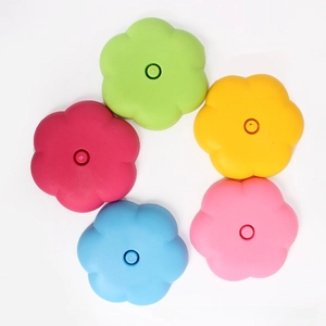 Close-up of five colorful flower-shaped plastic balloon stick holders on a white background