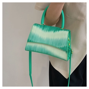 Close-up of green gradient crossbody handbag showing litchi grain texture and gold hardware