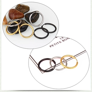 Detailed close-up of stainless steel hoop earrings in silver, gold, and black finishes