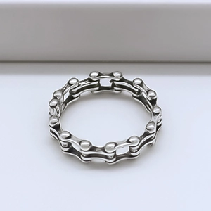 Détail de la bague chaîne de vélo argentée avec un design de style punk mécanique