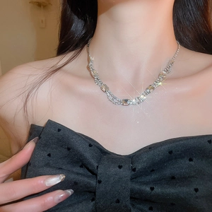 Close-up of a silver necklace with a diamond square pendant on a model with a bow