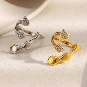 Close-up of gold and silver abstract wavy rings with micro-pave crystals decoration