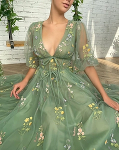 Macro detail of sage green evening gown with floral embroidery and mesh tulle texture