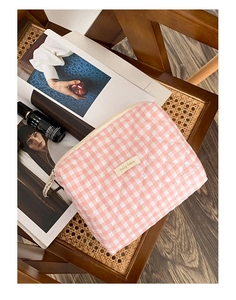 Détail de la trousse à maquillage matelassée à carreaux rose avec logo et zip