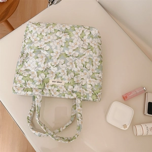 Close-up of quilted floral handbag with simple wish tag and daily cosmetic accessories