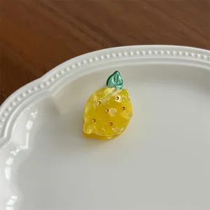Detail of yellow lemon hair clip with marble acetate texture and small sparkling crystals